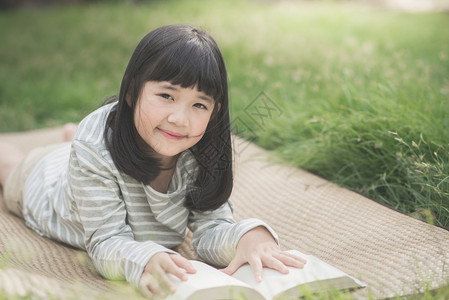 快乐的亚洲女孩读一本图片