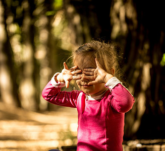 美丽的小女孩在森林里美丽的阳光在背景中图片