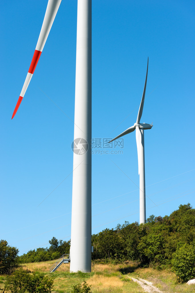 两台白色和红色风力涡轮机在清蓝的天空上图片