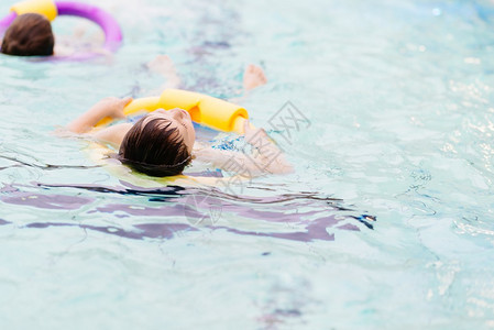 7岁男孩在游泳池学游泳图片