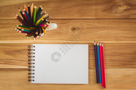 木桌上的彩色铅笔和速写本图片