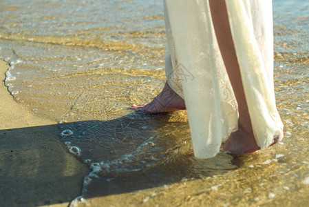 女孩赤脚在海滩上的沙滩图片
