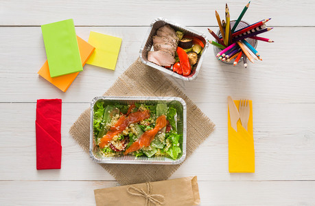 健康的午餐和饮食概念带走创意人员设计师或学生工作台上的铝箔盒纸和铅笔中的食物三文鱼和火鸡配蔬菜图片