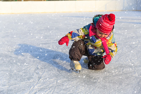 快乐的小女孩在冬天的雪地里滑冰图片
