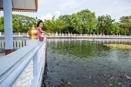 佛寺有一座大池塘有很多鱼女孩正在图片