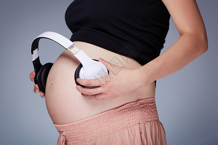 孕妇在肚子上放耳机的照片图片