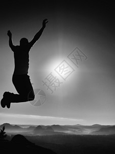 跳跃的人年轻的疯子在五颜六色的天空背景上跳跃跳跃的人和美丽的日落天空的剪影设计元背景图片