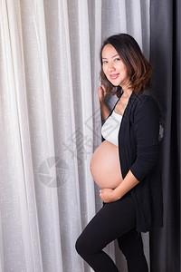 孕妇站在房间窗户图片