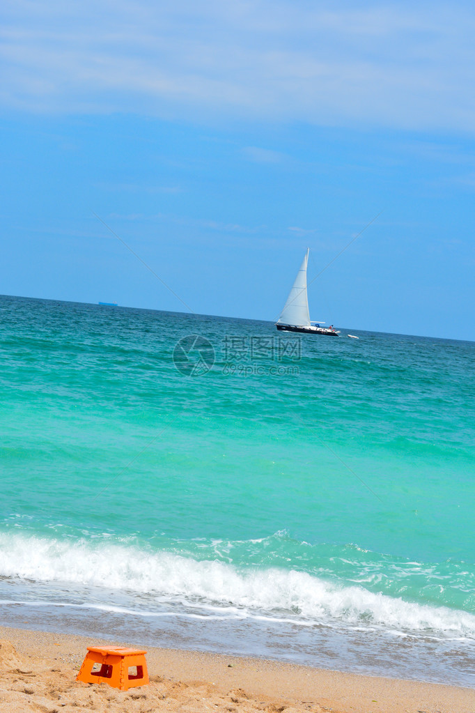 沙滩上可以看到帆船在碧海蓝天中漂流图片