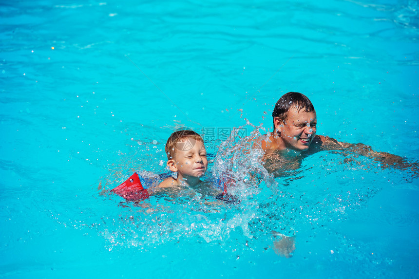 快乐的男孩享受与父亲一起游泳和溅水的乐趣幸福的家庭在游泳池的大海中玩耍孩子学游泳暑假概念爸和儿子在游图片