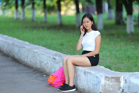 黑头发的女孩少女在鲍勃白色东亚女人绿色公园与背包景图片