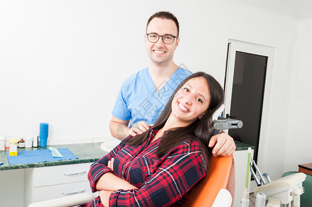 快乐的病人和牙医椅子上的医生微笑图片