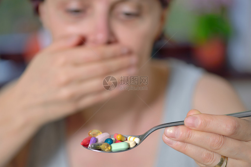 女人拿着勺子和药丸吃图片
