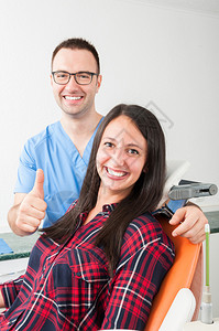 有病人坐在椅子上的牙医举起拇指来像友图片
