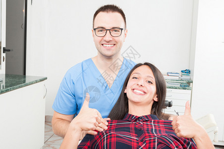 坐在牙医椅子上做拇指举起手势和与医图片