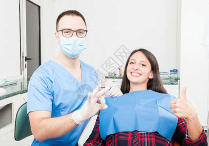 病人和医生举起拇指坐在牙医图片