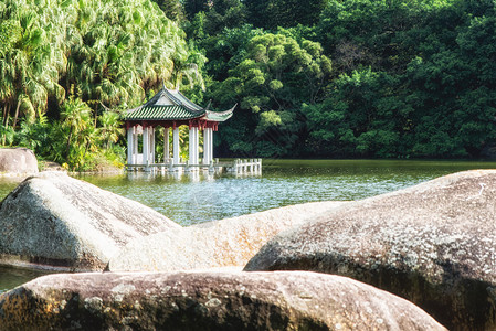 厦门南普陀寺附近植物园内湖面上的一座小亭子南普陀寺位于厦门岛东南部它被婀娜多姿的大海和寺庙后面的五老峰所环绕背景图片