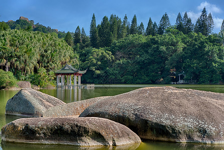 厦门南普陀寺附近植物园内湖面上的一座小亭子南普陀寺位于厦门岛东南部它被婀娜多姿的大海和寺庙后面的五老峰所环绕背景图片