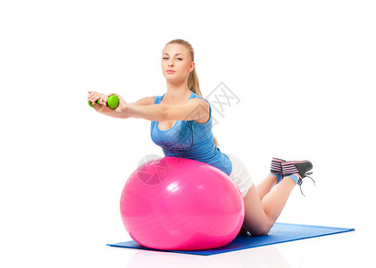 年轻女子与健身球和哑铃一起锻炼健身运动图片