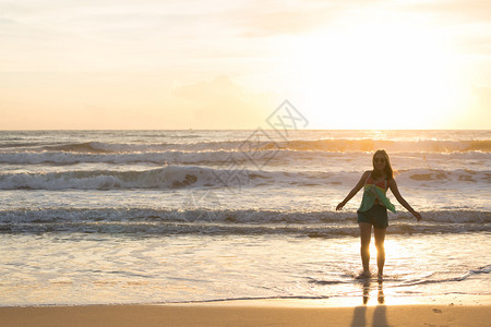 女人在沙滩上行走阳光照耀着早晨夏图片
