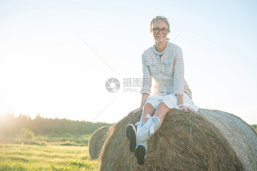 穿着雨靴的女孩坐在田图片