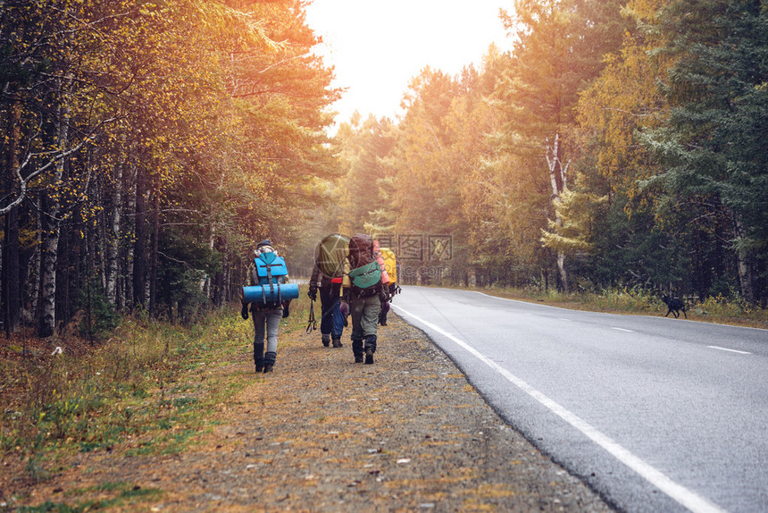 一群朋友背着包在日落时从后面走冒险旅行旅游远足和人们友谊的概图片