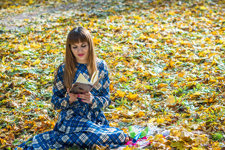 长直发的漂亮女孩穿着蓝色长裙在秋天图片