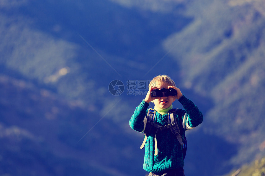 小男孩带着双筒望远镜在山上远图片