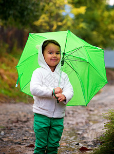 雨中拿着伞的女孩在水坑里奔流而过图片