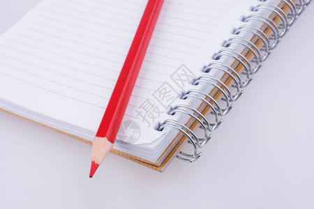 白色背景笔记本上的彩色铅笔图片