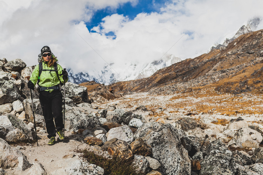 女徒步旅行者背着大背包在喜马拉雅山脉的落基小径上徒步旅行在高山和鼓舞人心的景观中徒步旅行的人看图片