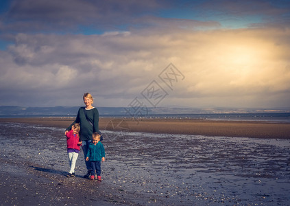 妈和她女儿和子在海滩上一起在空图片