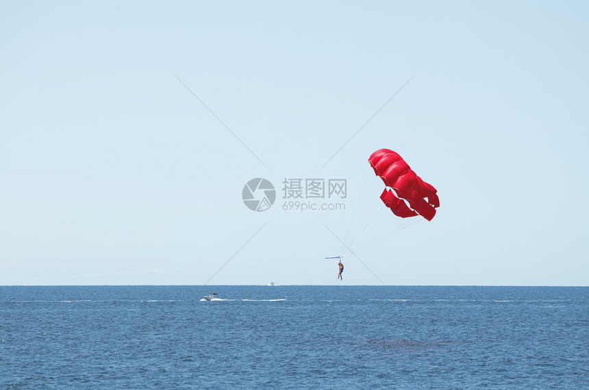 红色降落伞跳海和湛蓝的天空图片