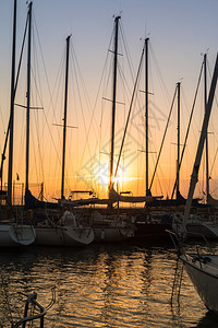 帆船的桅杆日落时的海边码头图片