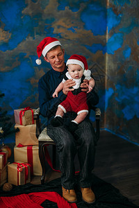 小可爱男孩和爷坐在圣诞树上图片