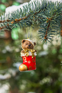 泰迪熊和红袜子在雪下圣诞树图片