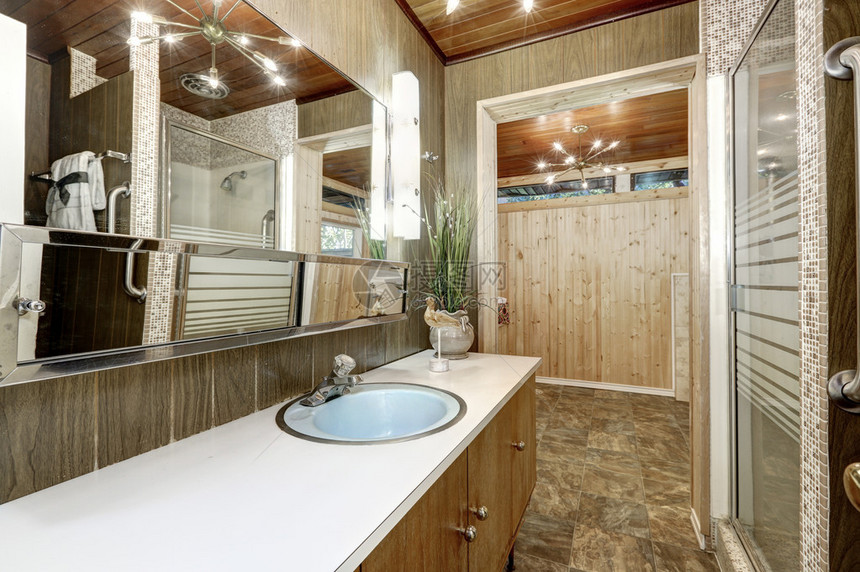 浴室内有木墙和棕色瓷砖地图片