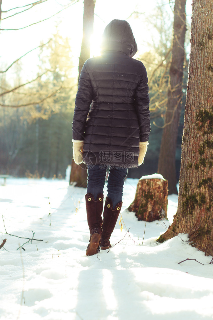 冬天森林里漂亮的红头发女孩在阳光明媚的一图片