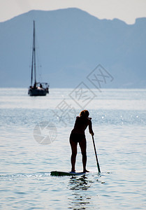 海里的女人站立式桨板冲浪图片
