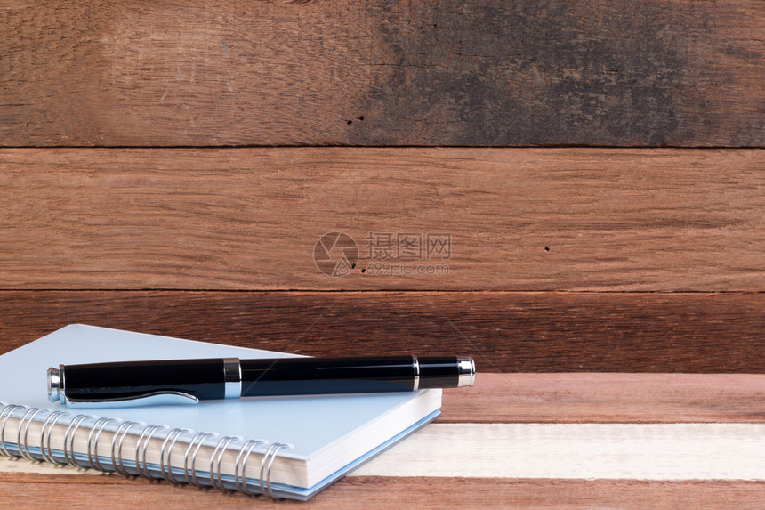 带有复制空间的木质纹理背景上的笔记本和笔空白笔记本和笔在木办公图片