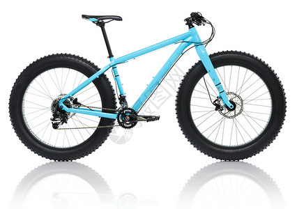 新的蓝色自行车有厚的雪车轮胎白图片