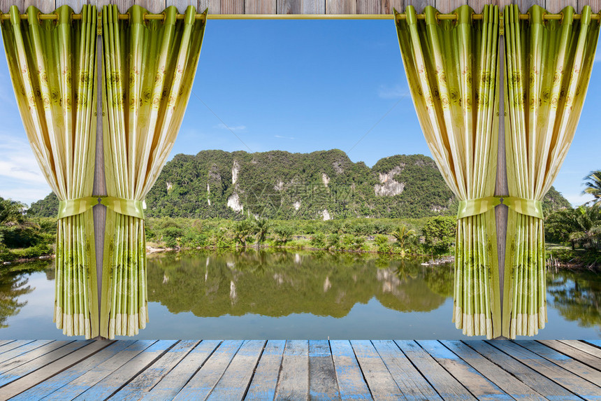 以美丽的绿窗帘和室内木质地板为透视窗口的图片