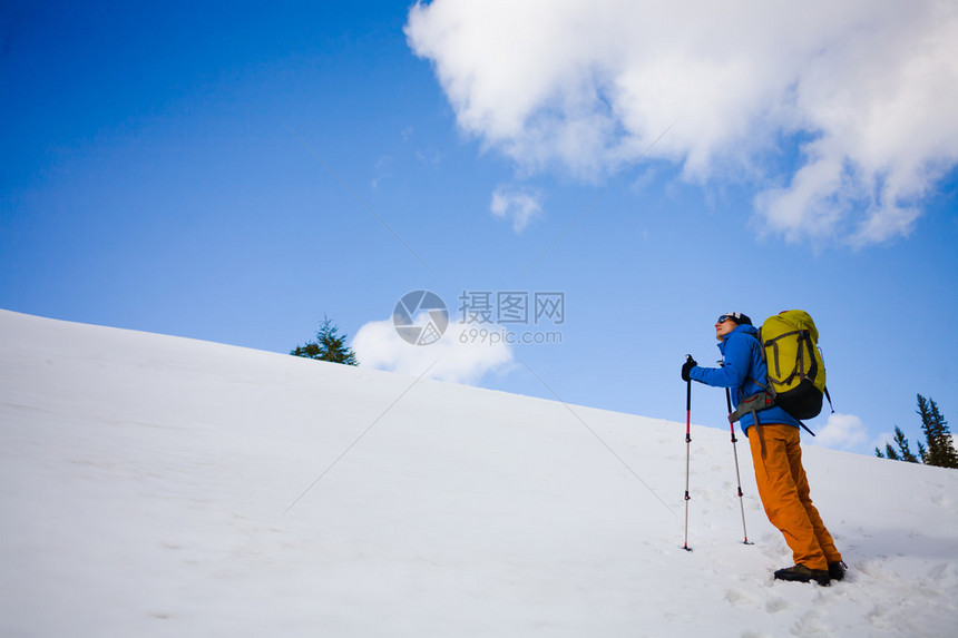 登山者在冬季徒步旅行时在雪山上图片