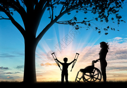 快乐的残疾儿童在轮椅旁边有拐杖是无效的图片