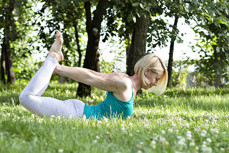 在草地上做瑜伽运动健身健康生活方式的背景图片