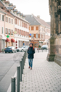 AlsaceThann村中央街道上行走的妇女图片