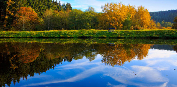 阳光明媚的日子里湖边的秋天森林阳光明媚的秋天风景与图片