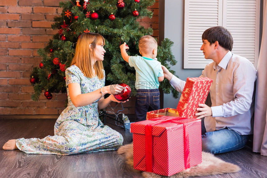 有孩子的圣诞节家庭打开圣诞礼物快乐微笑的父母和孩子在家庆祝新年圣诞图片