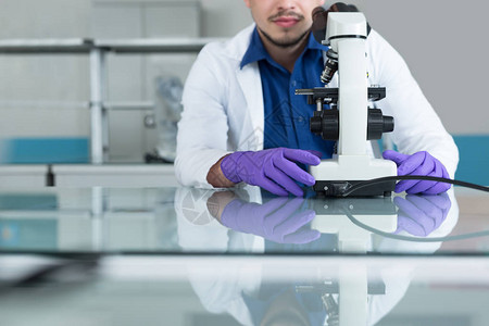 在实验室内部使用显微镜的caucasian男化学科图片