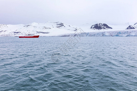 在大而巨大的Borebreen冰川前的探险或旅游船斯瓦尔巴群岛斯匹次卑尔根市奥斯卡二世土背景图片